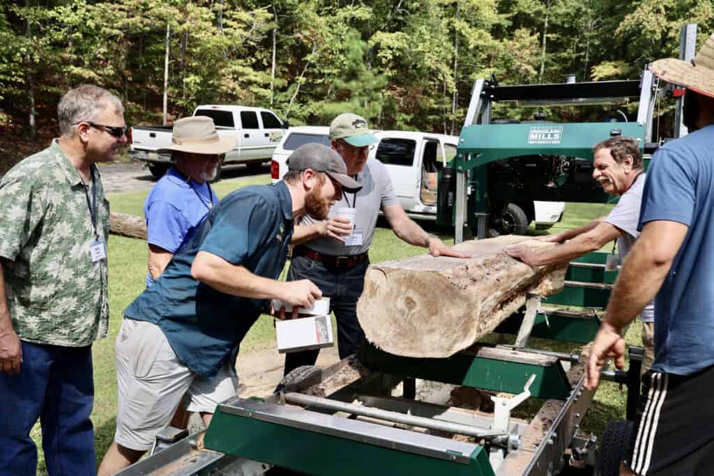 IWCS members checking out the beautiful grain on a log just milled at Shocco Springs, AL meeting